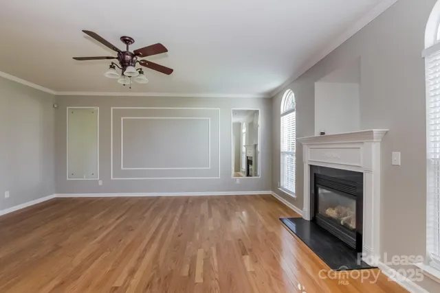 a view of empty room with wooden floor and fireplace
