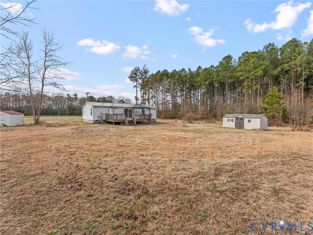 4772 Carsley Road Waverly, VA 23890 - Photo 31 of 38 View of grassy yard with a shed, a deck, and view