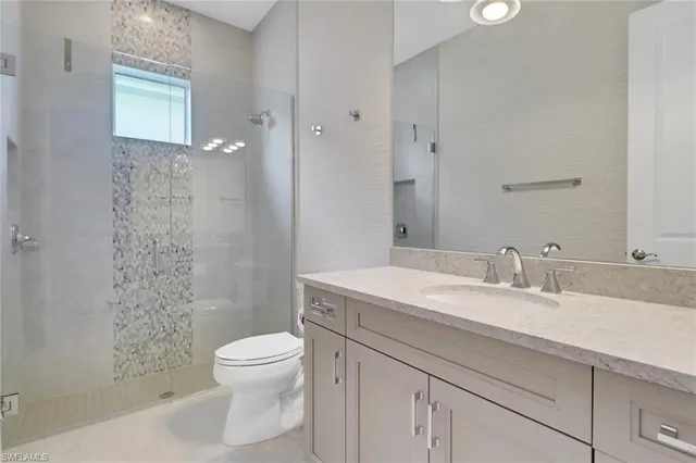 a bathroom with a granite countertop sink a toilet and a mirror