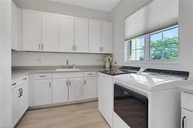 a kitchen with granite countertop white cabinets sink and window