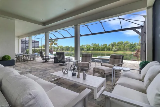 a living room with patio furniture and a floor to ceiling window