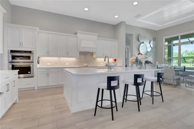 a kitchen with appliances cabinets and chair