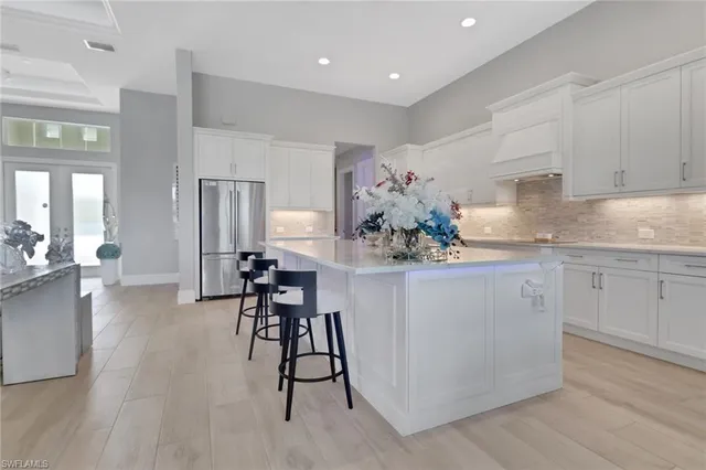 a kitchen with stainless steel appliances kitchen island granite countertop a table and chairs in it