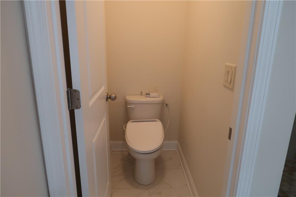 4334 Bellview Lane Duluth, GA 30097 - Photo 17 of 27 a white toilet sitting in a bathroom next to a sink