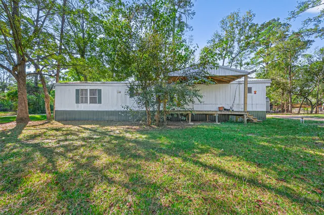 a view of a house with backyard and sitting area