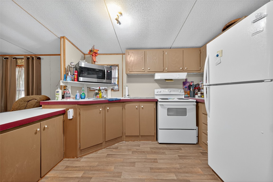 14 County Road 2400 Hull, TX 77564 - Photo 14 of 38 a kitchen with white cabinets and white appliances