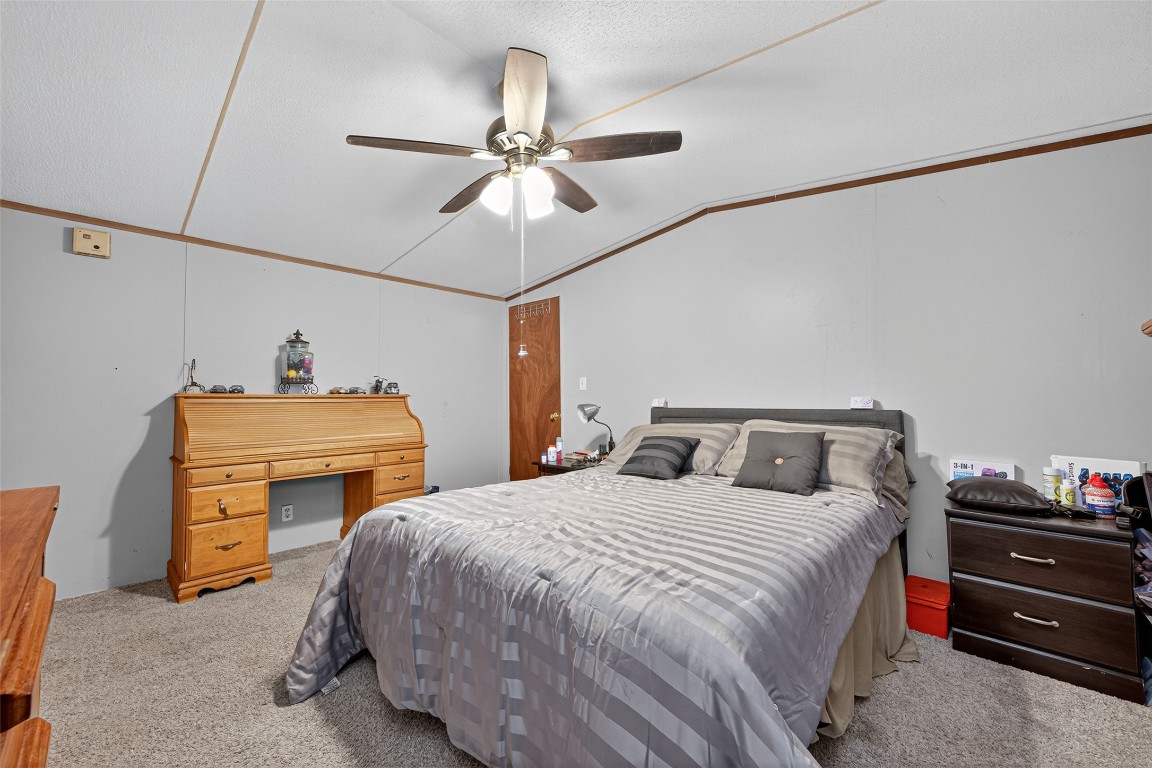 14 County Road 2400 Hull, TX 77564 - Photo 18 of 38 a bedroom with a bed and a chandelier
