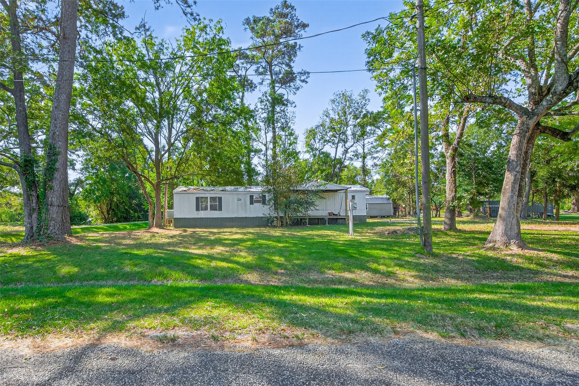 14 County Road 2400 Hull, TX 77564 - Photo 5 of 38 a backyard of a house with table and chairs plants and large tree