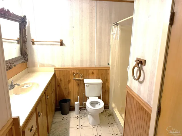 a bathroom with a granite countertop toilet and a sink