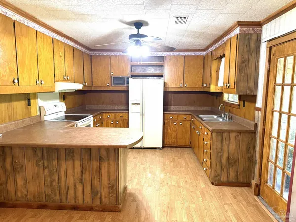 a kitchen with stainless steel appliances granite countertop a sink refrigerator and cabinets