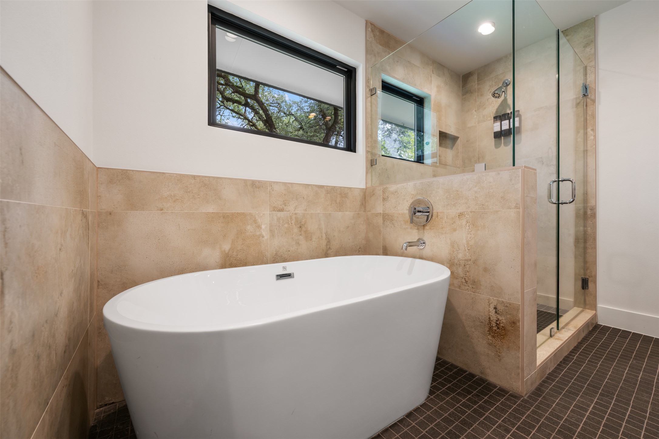 8900 Point W Drive Austin, TX 78759 - Photo 29 of 40 A deep soaking tub pairs with a frameless glass shower, creating a serene, contemporary bathing space.