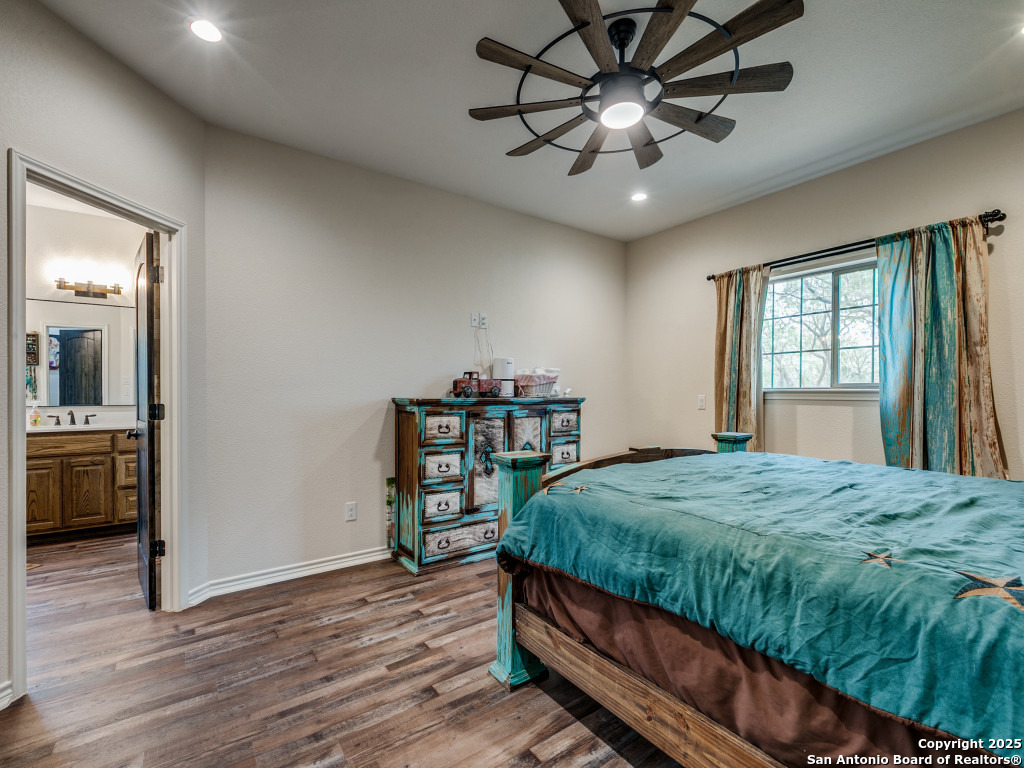 6451 Bluntzer Road Jourdanton, TX 78026 - Photo 12 of 51 a bedroom with a bed and a chandelier