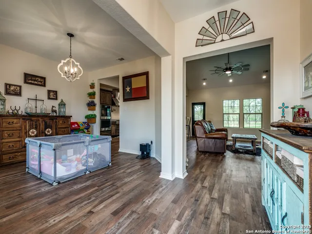 a kitchen with kitchen island granite countertop a stove a sink a refrigerator and a wooden floors