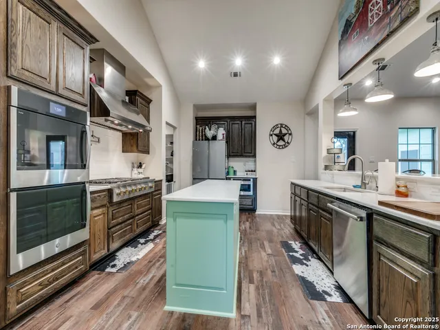 a kitchen with stainless steel appliances granite countertop a stove and cabinets