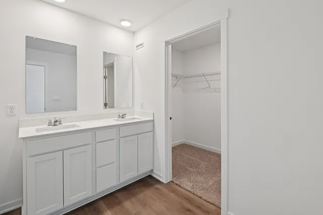 a bathroom with a double vanity sink and a mirror