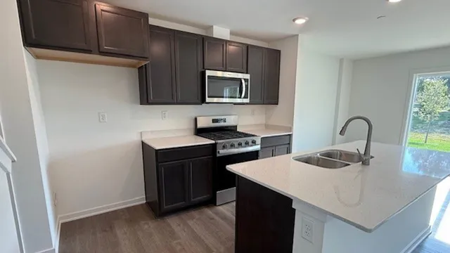 a kitchen with kitchen island a sink appliances and cabinets