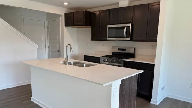 a kitchen with stainless steel appliances a microwave a sink and cabinets