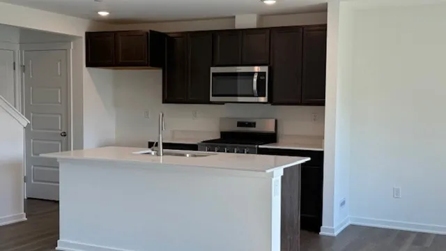 a kitchen with stainless steel appliances a microwave a sink and cabinets
