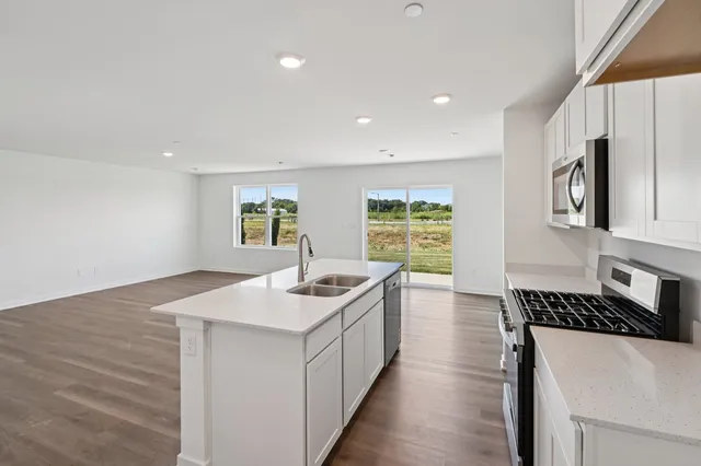 a kitchen with a sink stove and cabinets