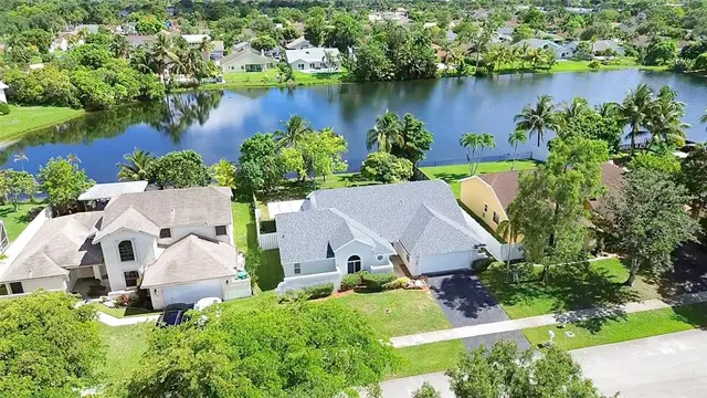 an aerial view of a house with a yard and lake view