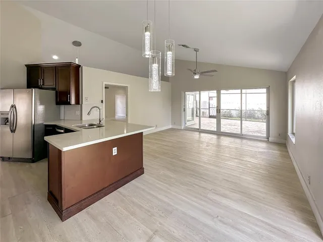 a large white kitchen with a large counter top space stainless steel appliances and a large window