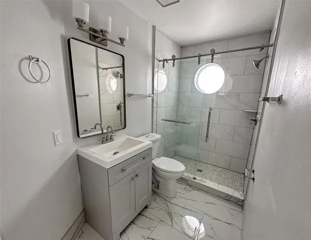 a bathroom with a toilet sink shower and mirror
