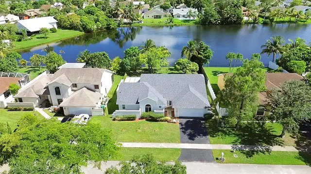 an aerial view of a house with a garden and lake view