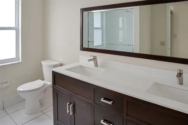a bathroom with a sink a toilet and mirror