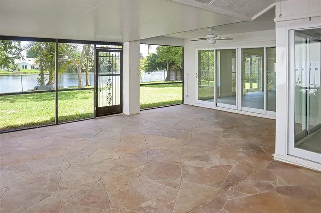 a view of an empty room with large windows and yard