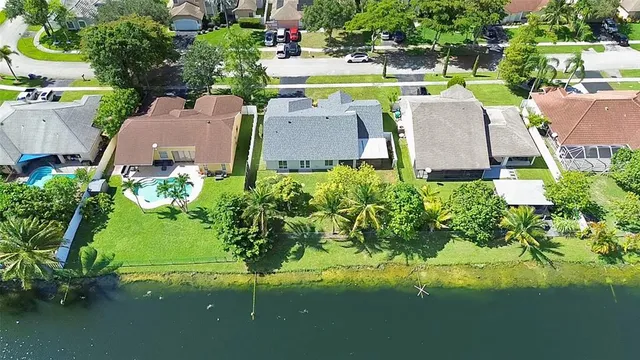 an aerial view of residential houses with outdoor space and lake view