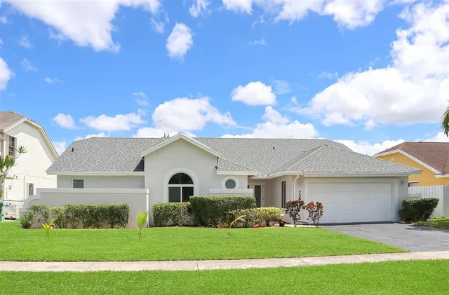 a front view of a house with a garden and yard