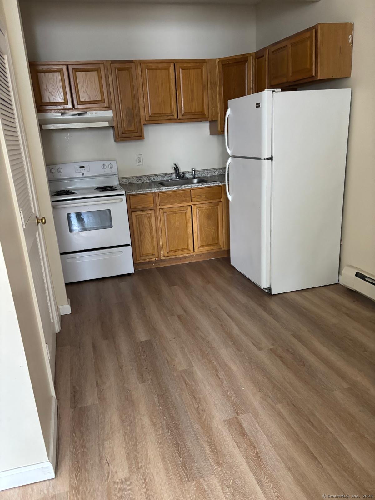 a kitchen with a refrigerator a stove top oven a sink and dishwasher