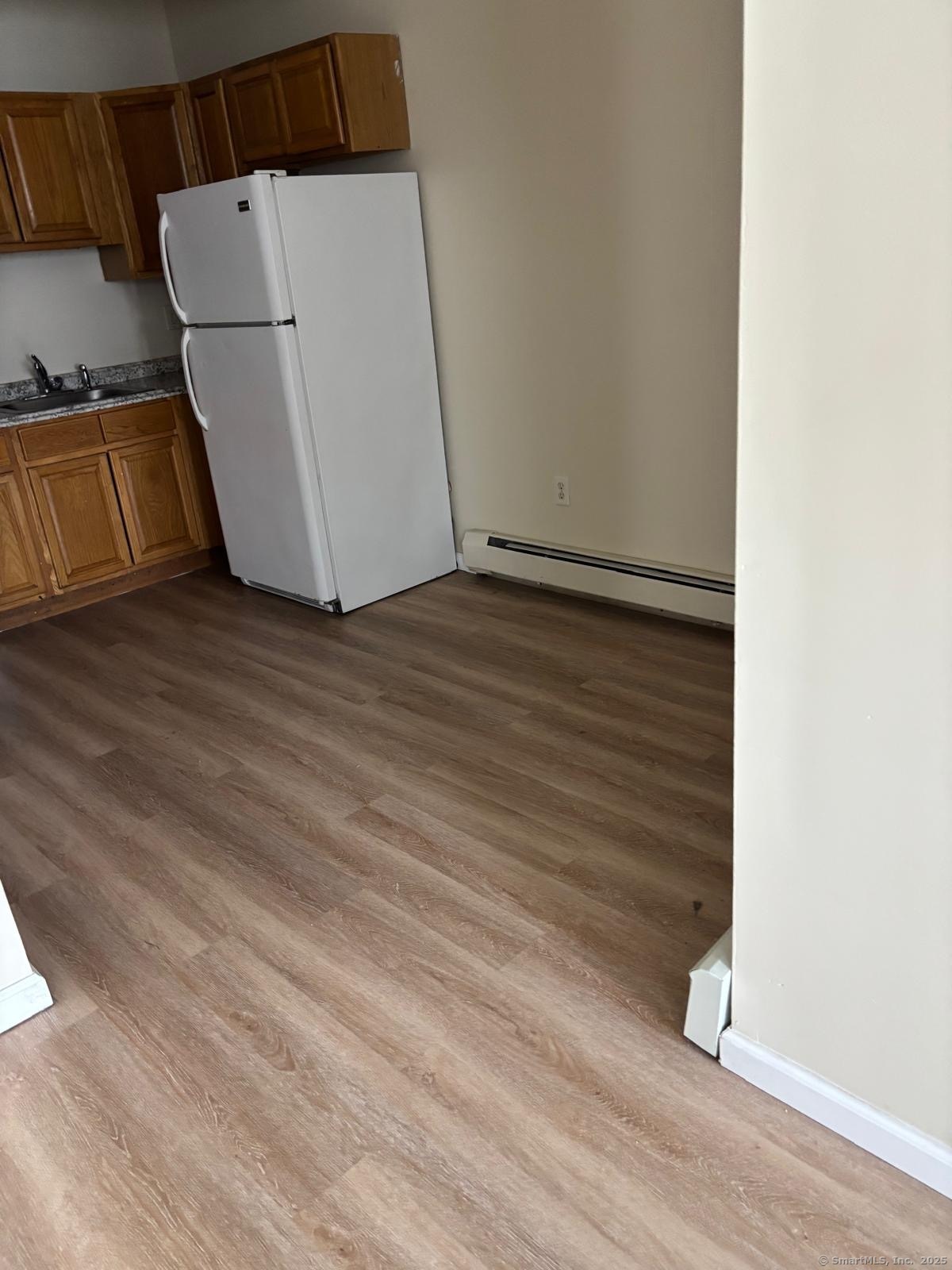 1057 East Main Street Bridgeport, CT 06608 - Photo 3 of 9 an empty room with wooden floor