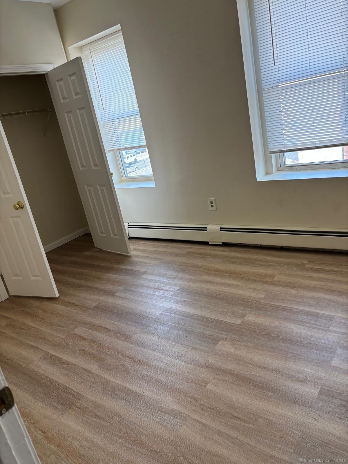 1057 East Main Street Bridgeport, CT 06608 - Photo 7 of 9 an empty room with wooden floor and windows