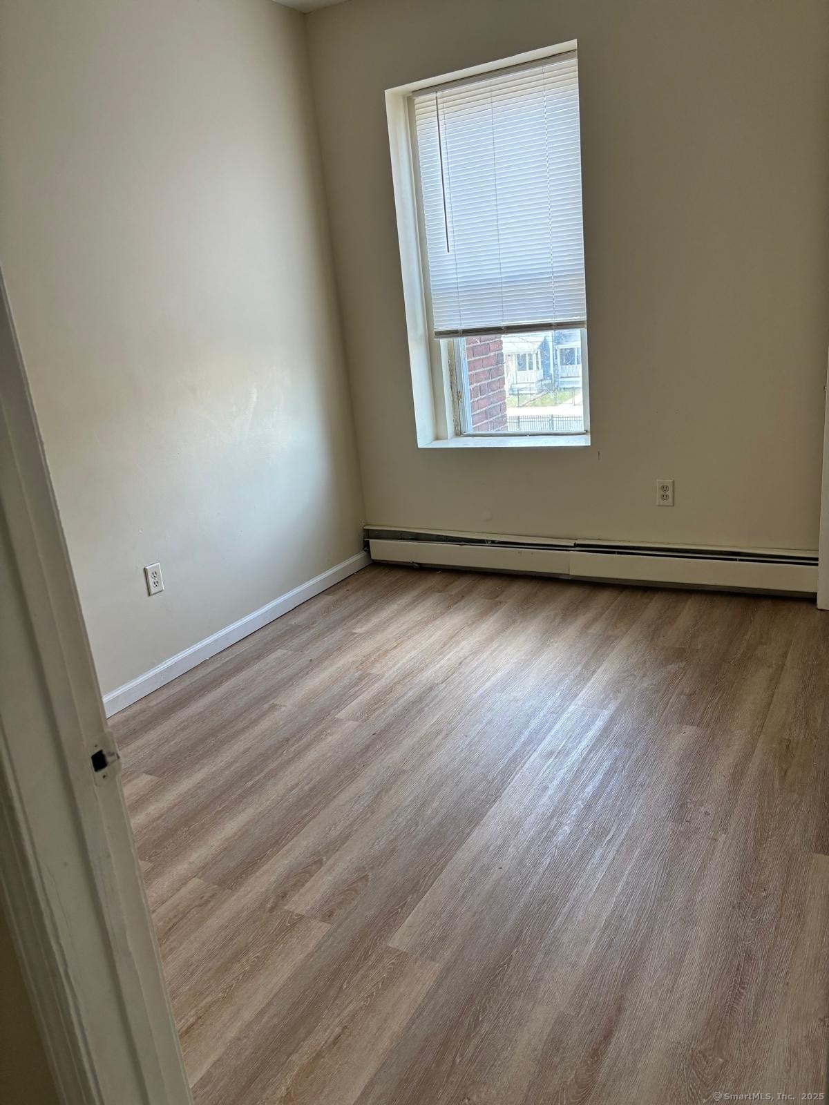 1057 East Main Street Bridgeport, CT 06608 - Photo 8 of 9 an empty room with wooden floor and windows
