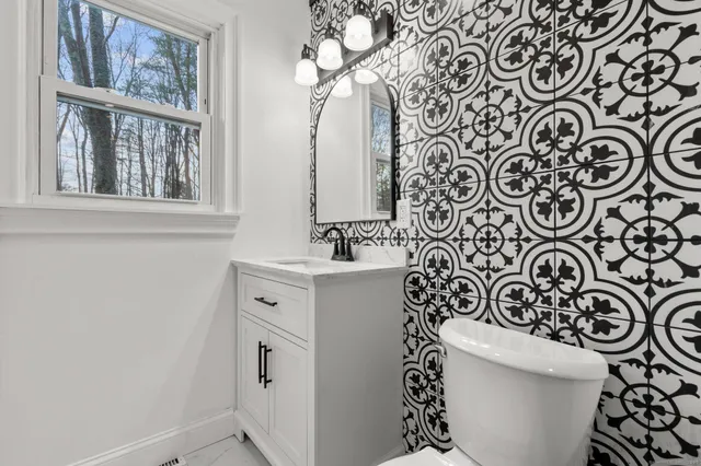 a bathroom with a sink a toilet and a mirror