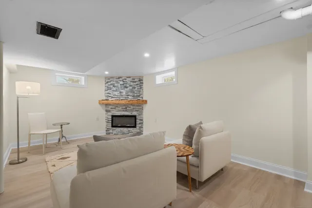 a living room with furniture a fireplace and a mirror