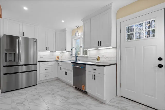 a kitchen with appliances a sink and a refrigerator