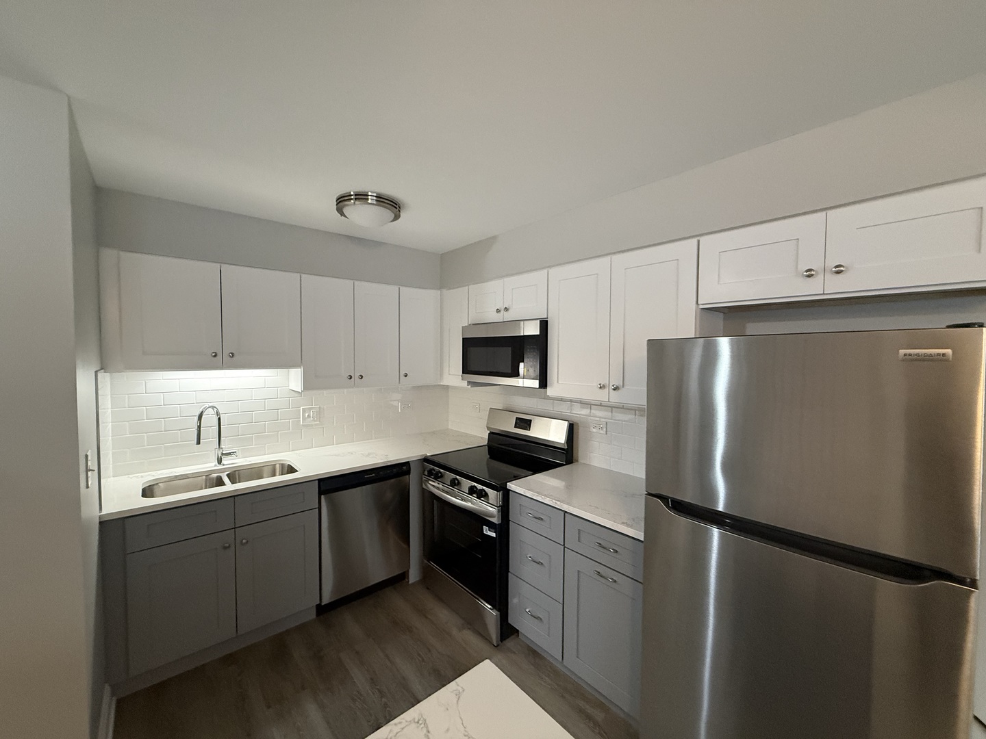 744 West Gordon Terrace, Unit 311 Chicago, IL 60613 - Photo 5 of 9 a kitchen with a sink a refrigerator and white cabinets