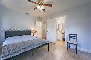1063 Mayford Lake Road Moore Haven, FL 33471 - Photo 20 of 39 a bedroom with a bed and a chandelier