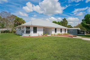 1063 Mayford Lake Road Moore Haven, FL 33471 - Photo 2 of 39 a front view of a house with a garden