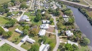 an aerial view of residential houses with outdoor space and lake view