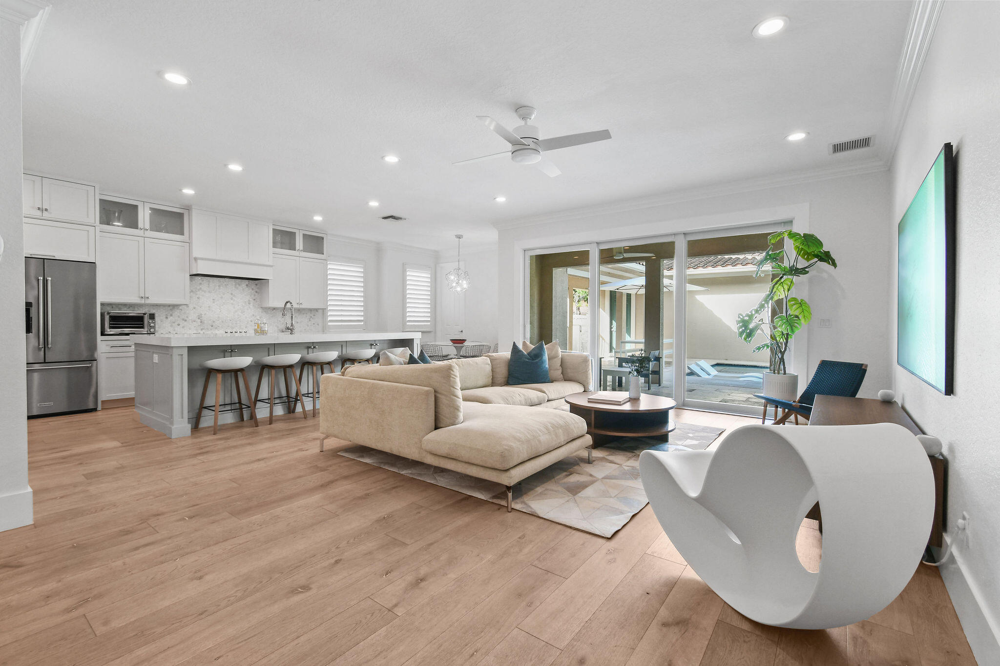 a living room with stainless steel appliances granite countertop furniture and a wooden floor