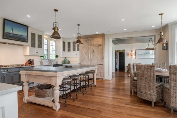 a kitchen with stainless steel appliances granite countertop a kitchen island hardwood floor and a sink