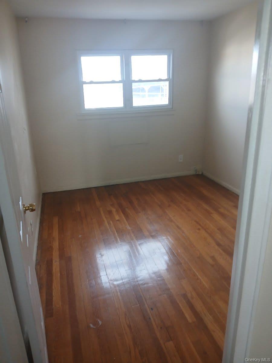 255-29 149th Road Queens, NY 11422 - Photo 17 of 23 an empty room with wooden floor and windows