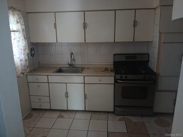 a kitchen with a stove and white cabinets