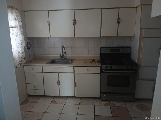 a kitchen with a stove and white cabinets