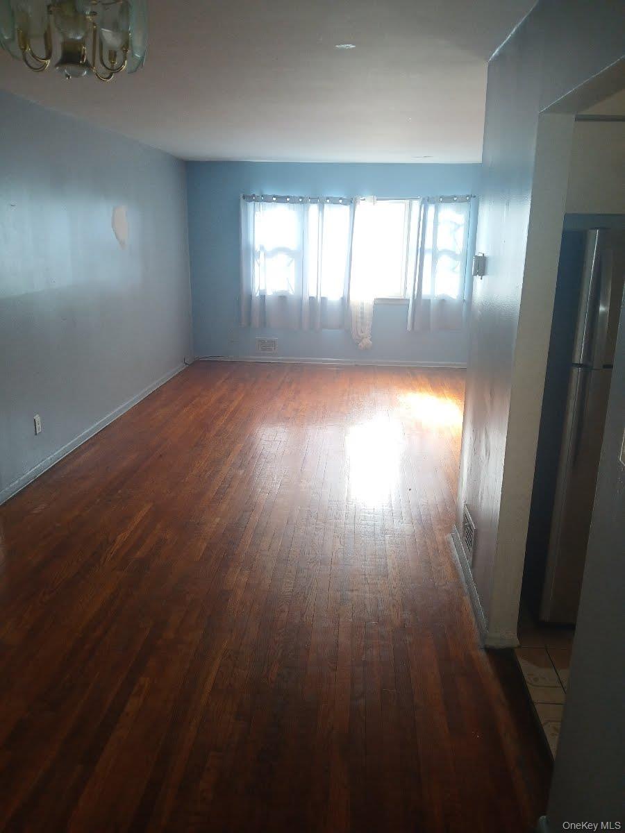255-29 149th Road Queens, NY 11422 - Photo 7 of 23 an empty room with wooden floor and windows