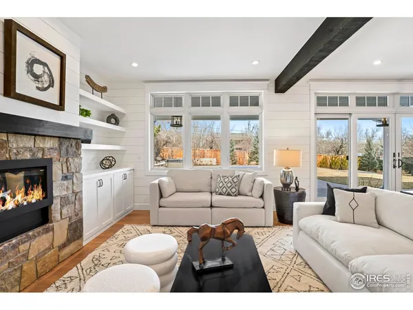 a living room with furniture fireplace and a large window
