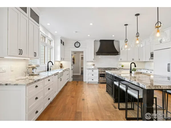 a kitchen with granite countertop a sink stove and cabinets
